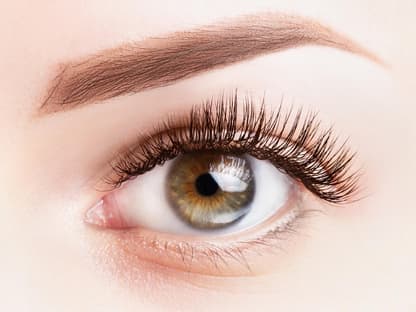 Frau nutzt Mascara mit Falsche-Wimpern-Effekt