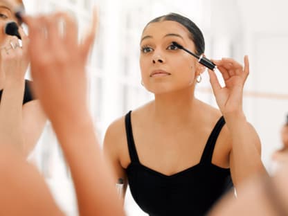 Frau betont ihre Wimpern mit Mascara