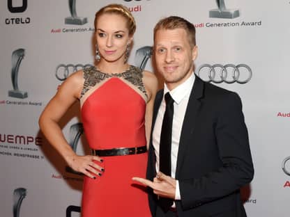 Sabine Lisicki und Oliver Pocher posieren vor einer weißen Wand