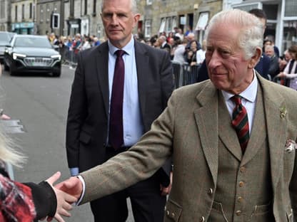 König Charles III. Schottland, er schüttelt einer Frau die Hand.