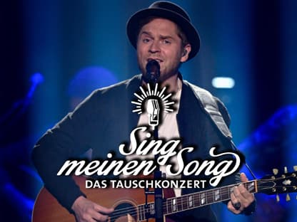 Johannes Oerding singt und spielt Gitarre, vor ihm das "Sing meinen Song"-Logo