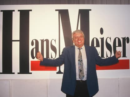 Hans Meiser vor einem Plakat zur Talkshow "Hans Meiser"