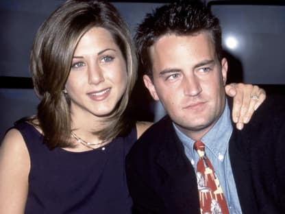 Jennifer Aniston legt lächelnd den Arm um Matthew Perry