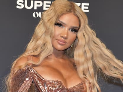 Shirin David fährt sich mit strengem Gesichtsausdruck durch die langen Haare