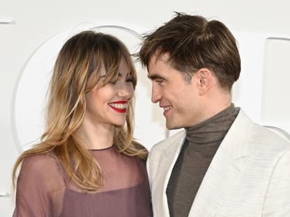 Robert Pattinson und Suki Waterhouse lächeln sich an