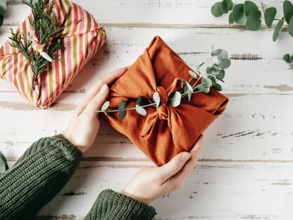 Furoshiki – Hände halten ein nachhaltig verpacktes Geschenk