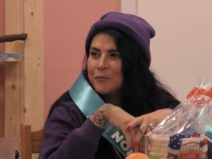 Iris Klein sitzt am Tisch bei "Promi Big Brother" und guckt ernst