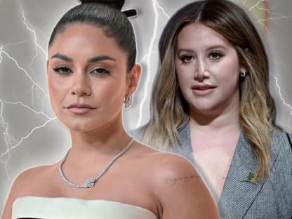 Vanessa Hudgens sieht entschlossen aus, Ashley Tisdale steht mit bedrücktem Gesicht hinter ihr, zwischen ihnen schießen Blitze