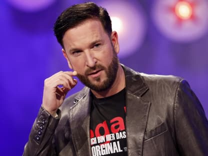 Michael Wendler greift sich an sein Mikrofon im Gesicht