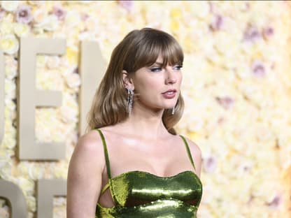 Taylor Swift im grünen Kleid guckt ernst zur Seite bei den Golden Globes 2024