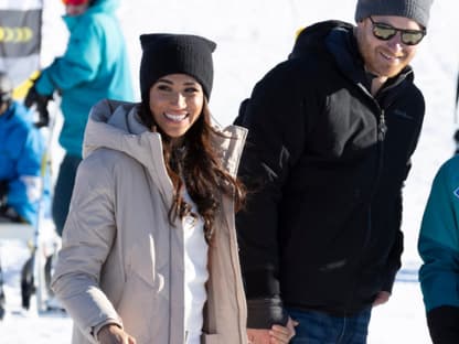 Herzogin Meghan und Prinz Harry laufen Hand in Hand. 