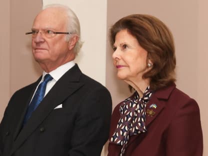 König Carl Gustaf und Königin Silvia schauen ernst. 