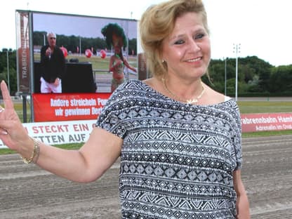 Silvia Wollny lächelt und zeigt mit den Fingern Peace