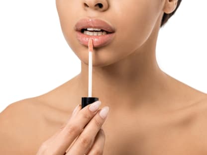 Frau mit Lipgloss für volle Lippen