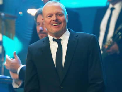 Stefan Raab lächelt im Anzug