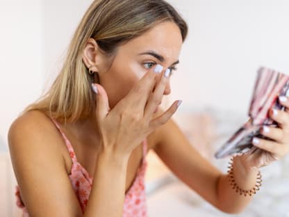 Frau trägt Concealer auf