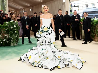 Gigi Hadid mit weißen Kleid mit gelben Blumen und roten Lippen bei der MET Gala 2024