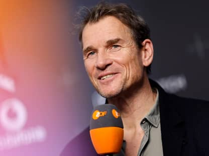 Jens Lehmann lachend am Mikrofon