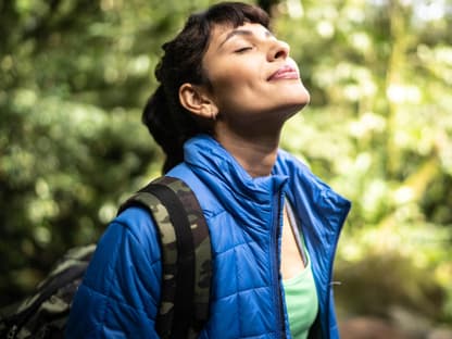 Frau atmen im Wald tief durch