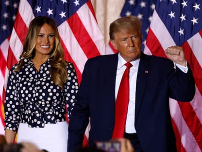 Melania & Donald Trump mit USA-Flaggen im Hintergrund