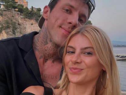 Romina Palm und Christian Wolf posieren am Strand und machen ein Selfie