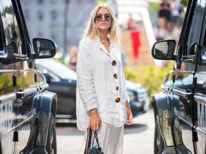 Eine Frau in einer weißen Bluse und angesagter Sonnenbrille