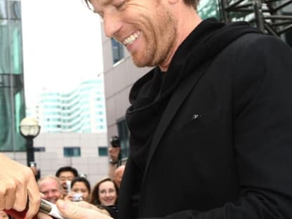 Ewan McGregor gibt den wartenden Fans fleißig Autogramme. Er spielt in seinem neuen Film an der Seite von George Clooney