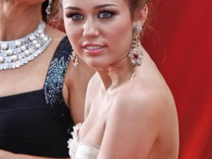 Miley Cyrus erschien auf dem roten Teppich mit einer tollen Hochsteckfrisur und einer Bustierrobe von Jenny Packham. Sie übergab den Preis für den besten Film-Song