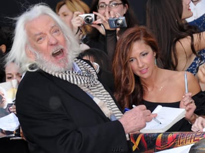 Donald Sutherland schreibt gut gelaunt Autogramme für die wartenden Fans. Übrigens: "Die Tribute von Panem - The Hunger Games“ kommt am 22. März in die deutschen Kinos