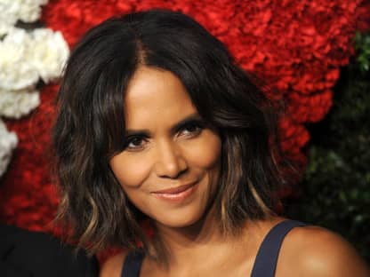 Halle Berry lächelt leicht vor Rosen