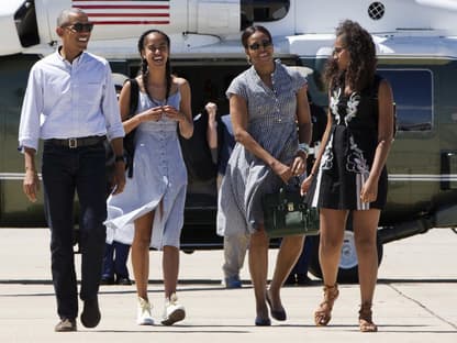 Barack und Michelle Obama mit ihren Töchtern Malia und Sasha vor einem Hubschrauber.