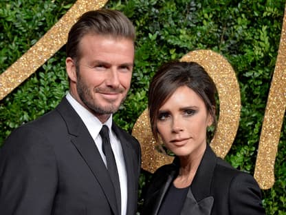 David und Victoria Beckham posieren vor grüner Wand