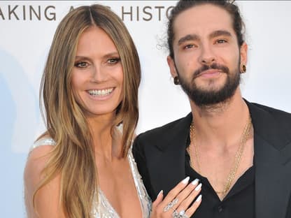 Heidi Klum legt lächelnd ihre Hand auf Tom Kaulitz' Brust