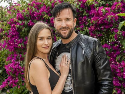 Laura Müller und Michael Wendler mit einem Blumenhintergrund