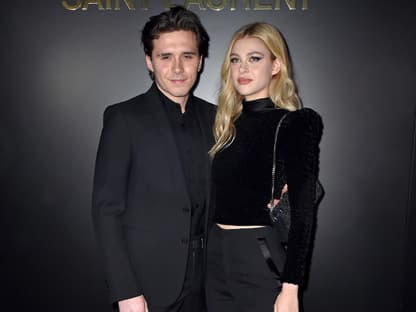 Brooklyn und Nicola Peltz-Beckham posieren vor einer schwarzen Wand