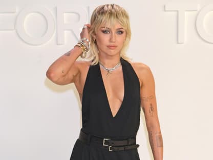 Miley Cyrus streift sich die Haare hinters Ohr