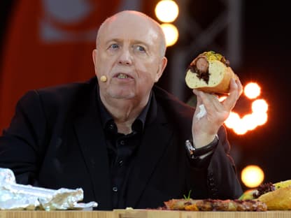 Reiner Calmund isst ein Brot mit Würstchen bei "Grill den Henssler"