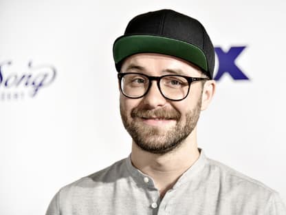 Mark Forster posiert vor einer weißen Wand