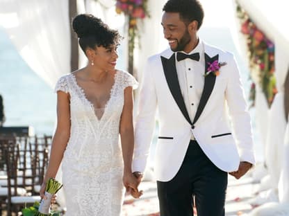 Maggie Pierce und Winston schauen sich lächelnd an auf ihrer Hochzeit