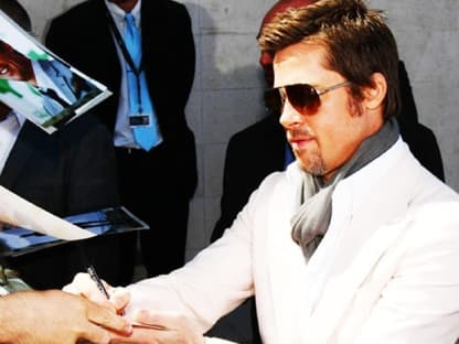 Brad Pitt schreibt Autogramme