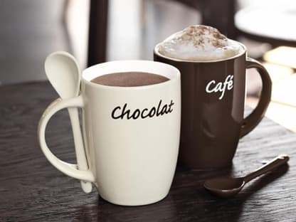 2 Trinkbecher mit Löffeln: jeweils mit Café- und Chocolat-Schriftzug. Braun und cremefarben im Set. Preis 9,99 Euro