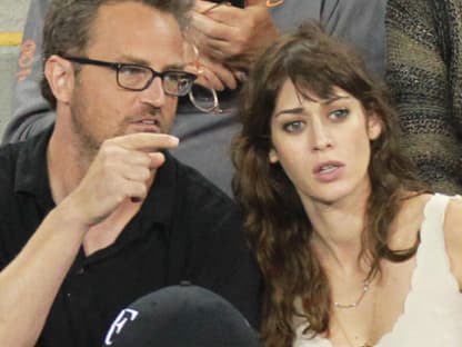 Geduldig erklärt er seiner Freundin Lizzy Caplan das Spiel