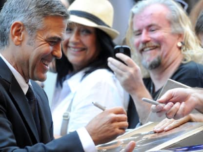 Weiß, was Frauen und Fans wollen: George Clooney schrieb eifrig Autogramme auf der "The Descendents"-Premiere in Toronto