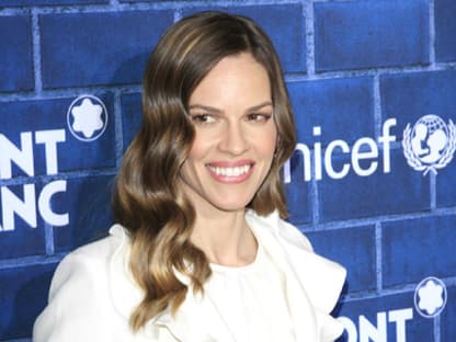 Das "Million Dollar Baby" Hilary Swank strahlt auf dem roten Teppich in einem weißen Rüschen-Entwurf.