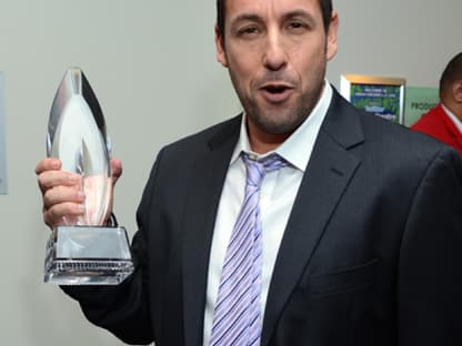 Adam Sandler hält stolz seinen Preis in die Kameras