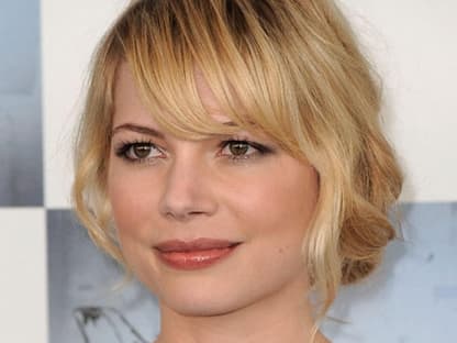 Michelle Williams lässt ihren Pony locker ins Gesicht fallen. Die lockere Hochsteckfrisur wirkt sehr mädchenhaft