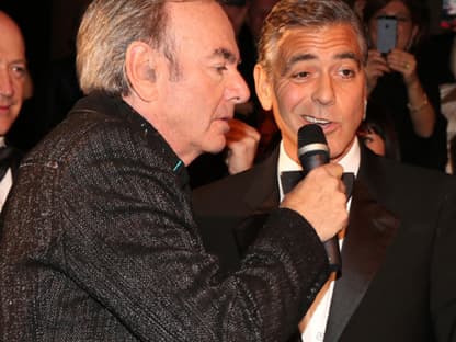 Erst kurzes Zögern bei George Clooney, der von Sänger Neil Diamond das Mikrofon an den Mund gehalten bekam ...