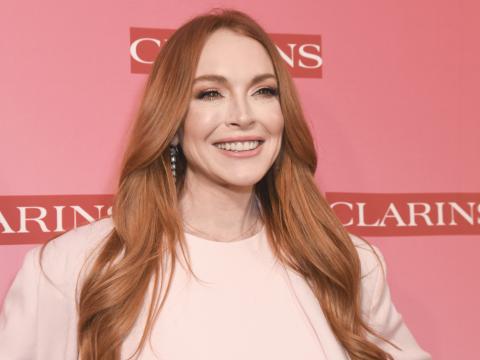 Lindsay Lohan strahlt vor pinkem Hintergrund