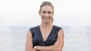 Dr. Christine Theiss lacht mit gekreuzten Armen am Meer