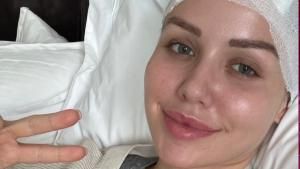 Kim Gloss mit Verband um den Kopf im Krankenhausbett